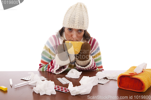 Image of woman with flu symptoms drinking a hot drink