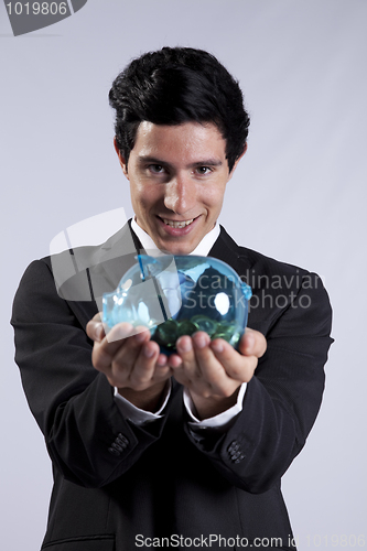 Image of Businessman holding a piggybank full of coins