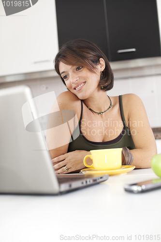 Image of Modern woman reading e-mails at her breakfast