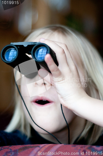 Image of Young girl looking trought binoculars