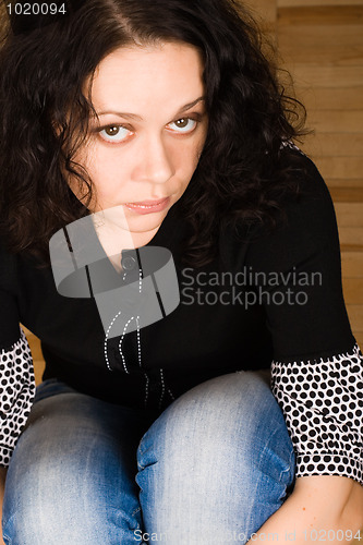 Image of woman sitting on a wooden floor