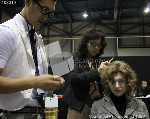 Image of Korean stylists prepare a Russian model for the runway