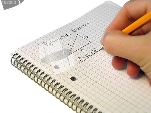 Image of Student, writing down Pythagoras theorem in a notebook.