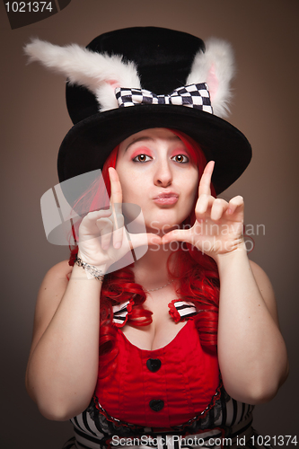 Image of Attractive Red Haired Woman Wearing Bunny Ear Hat Framing Face