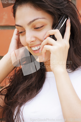 Image of Happy woman in white talking cellphone