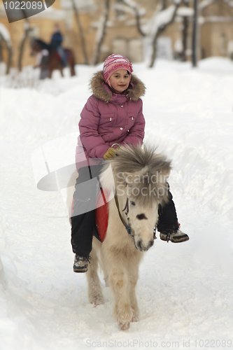 Image of Little girl on a white pony