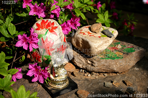 Image of Buddha image sitting on painted rocks