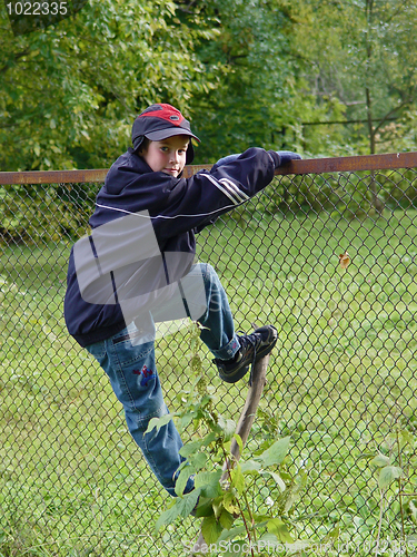 Image of Young Boy climbing a fence