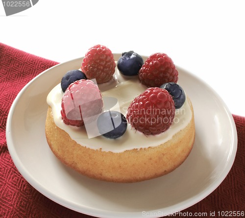 Image of small cake dessert  with raspberries and blueberries