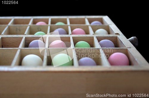 Image of pastel balls in a type case