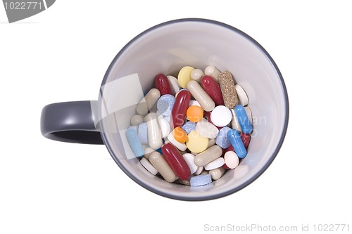 Image of cup of multicolored tablets and capsules