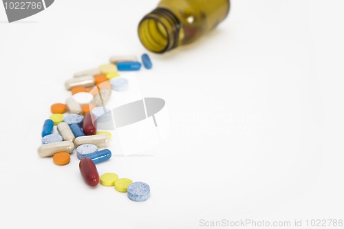 Image of colorful stream of pills coming from a pill bottle