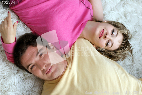 Image of Sweet young couple lying on the rug