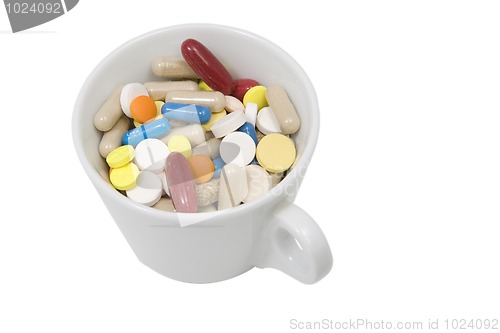 Image of cup of multicolored tablets and capsules