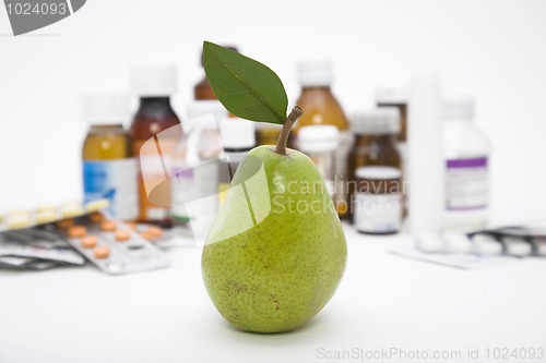 Image of green pear in front of pills