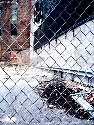 Image of dirty NYC puddle behind fence