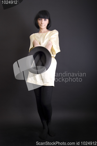 Image of Young brunette holding an empty hat    