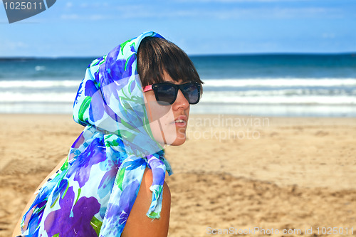 Image of young beautiful woman with scarf in the beach