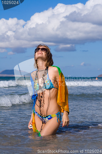 Image of young blond woman with kerchief on  the beach