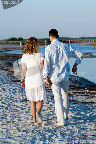 Image of Young couple walking on beach