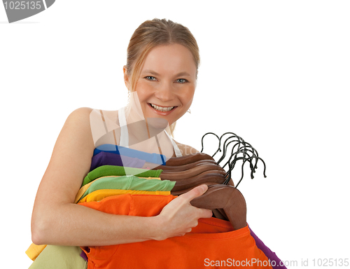 Image of Charming young woman holding colourful clothes