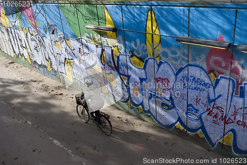 Image of Cyclist riding along graffiti