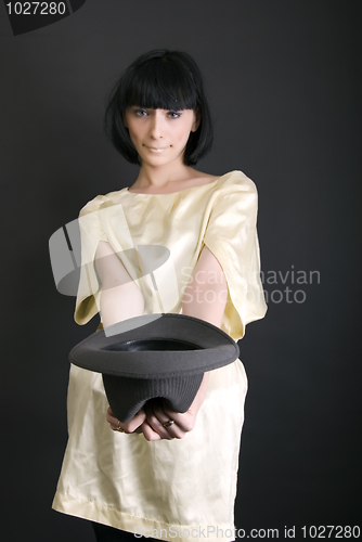 Image of Young brunette holding a hat  