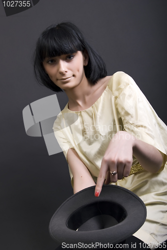 Image of Young brunette holding a hat    