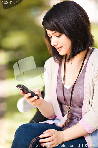 Image of Mixed race student texting