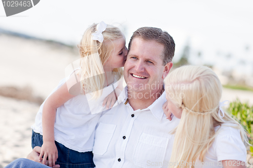 Image of Handsome Dad Getting Kisses from His Cute Daughters 