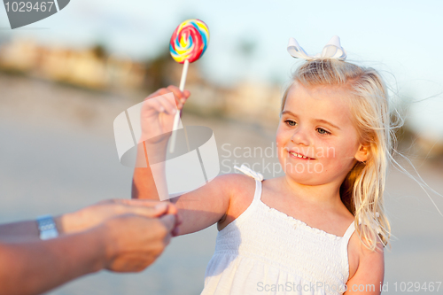 Image of Adorable Little Girl Picking out Lollipop Outside