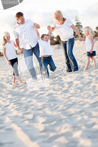 Image of Happy Young Boy Swinging with His Parents