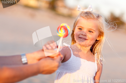 Image of Adorable Little Girl Picking out Lollipop Outside