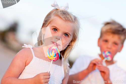 Image of Cute Little Girl and Brother Enjoying Their Lollipops