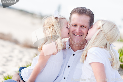 Image of Handsome Dad Getting Kisses from His Cute Daughters 