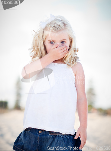 Image of Adorable Blue Eyed Girl Covering Her Mouth