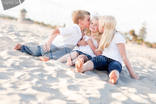 Image of Adorable Sibling Children Kissing the Youngest
