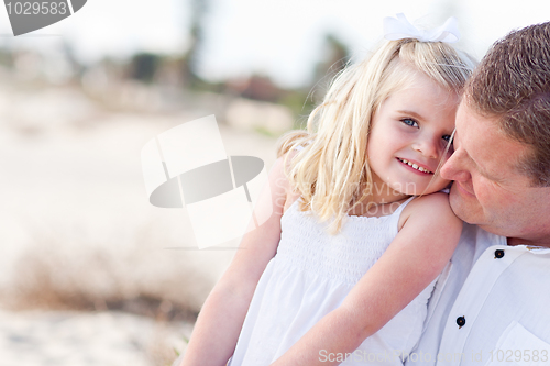 Image of Cute Daughter Cuddles up with Her at the Beach