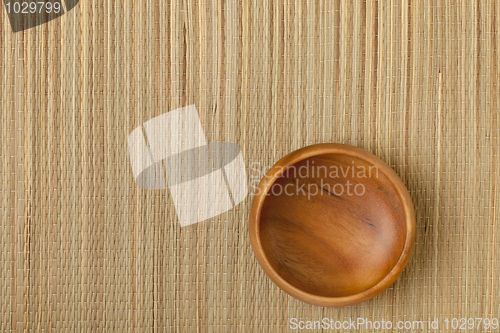 Image of empty wooden bowl on mat