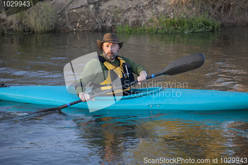 Image of adult paddler in blue kayak