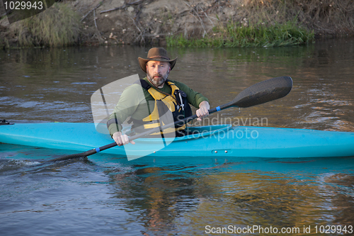 Image of adult paddler in blue kayak
