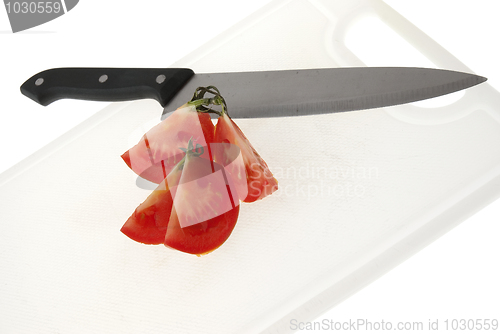 Image of Cutting white plastic board with a knife and tomato