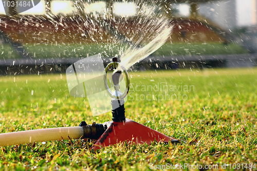 Image of Water jets sprinkling stadium field