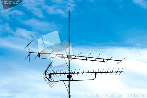 Image of old analog television antenna against blue sky