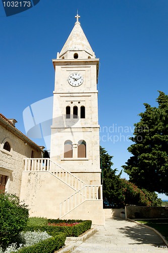 Image of small romantic historical church trust with clock 