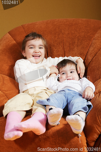 Image of Funny sisters sitting in chair