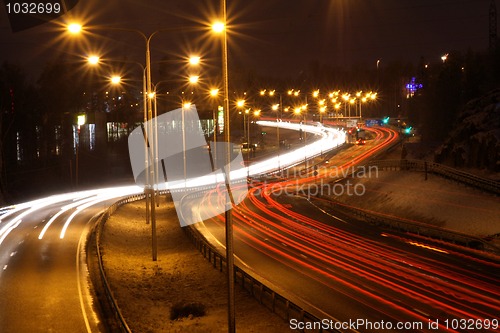 Image of Car lights in the night on the town highway in winter