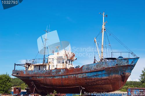 Image of Old, rusty fishing launch on building berths in port 