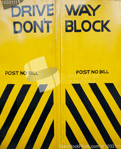 Image of black and yellow gate with sign