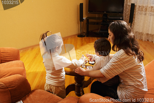 Image of Mother playing with daughters at home